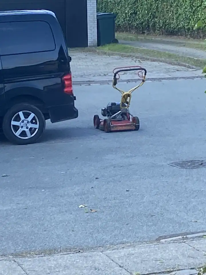 Plæneklipper klar ved havemandens bil